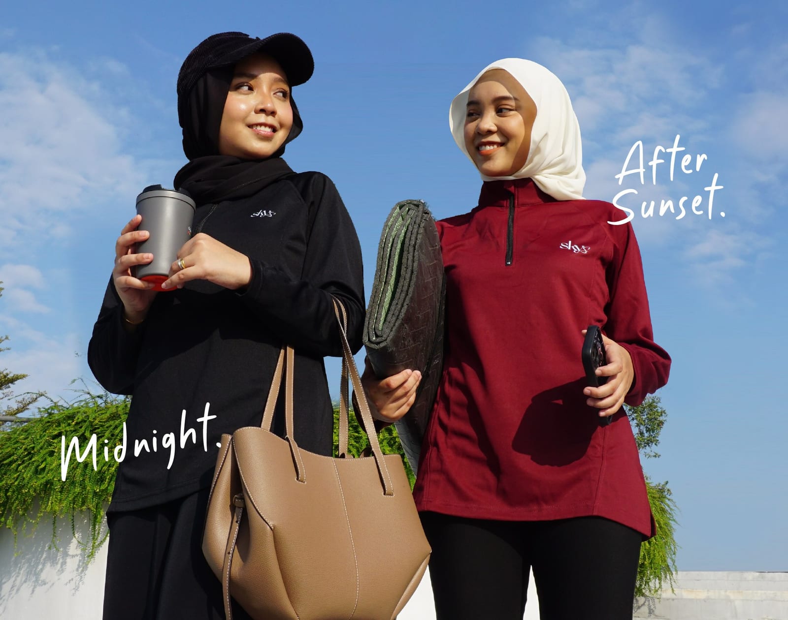 Two friends in Skys half-zips — Midnight black and After Sunset maroon — under a blue sky